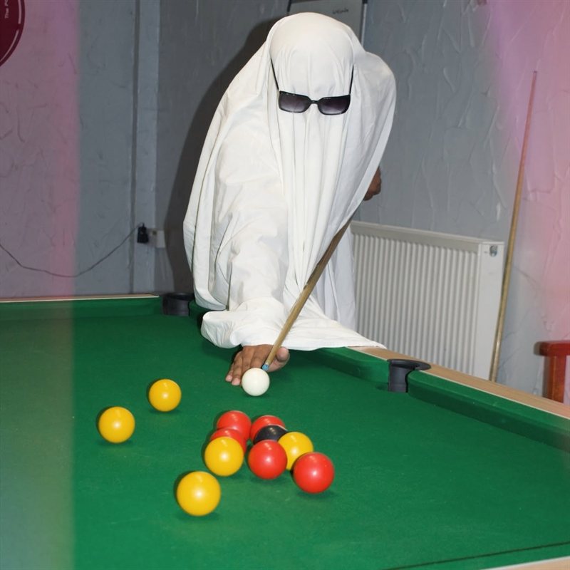 The ghost in sunglasses lining up a shot at the pool table